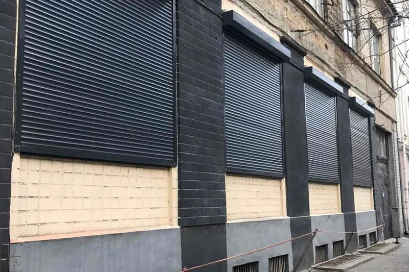 Антрацитові ролети на вікнах старого міського будинку